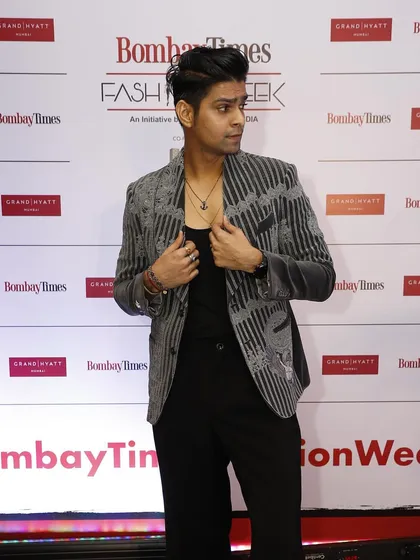 This red carpet shot shows how the grey velvet coat catches the light, emphasizing the rich texture of the fabric and the intricacy of the hand-stitched details.