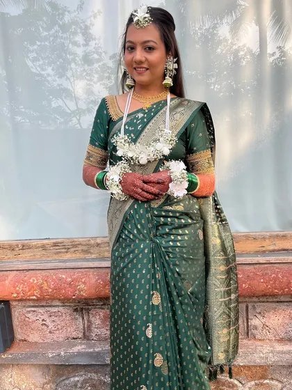 Kritika's Haldi look, featuring a beautiful green saree and traditional floral jewellery.