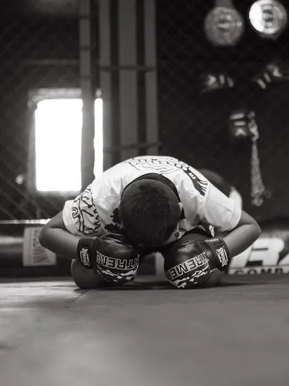 A black and white shot of a young fighter bowing, a sign of humility and respect.