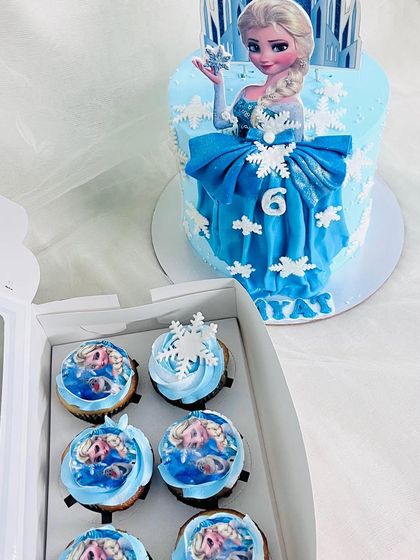 The Elsa cake paired with matching Frozen-themed cupcakes.