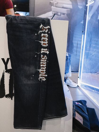 A close-up of customized graffiti art on a pair of dark wash jeans.