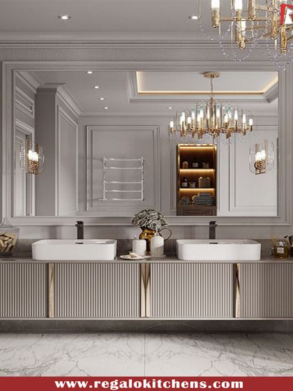 A grand, traditional vanity with dual sinks and ornate lighting fixtures. The fluted cabinet fronts and large mirror create a feeling of classic, timeless elegance.