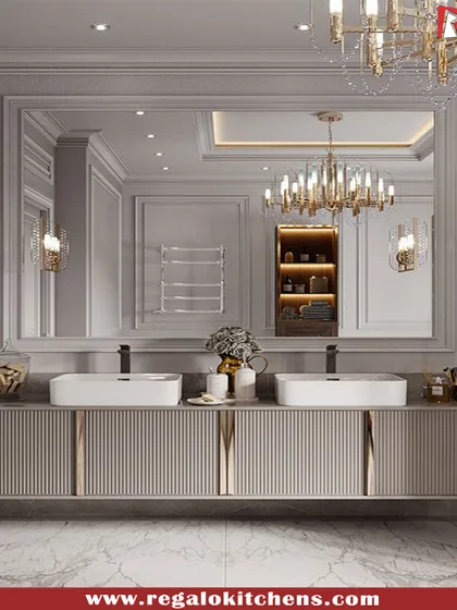 A grand, traditional vanity with dual sinks and ornate lighting fixtures. The fluted cabinet fronts and large mirror create a feeling of classic, timeless elegance.