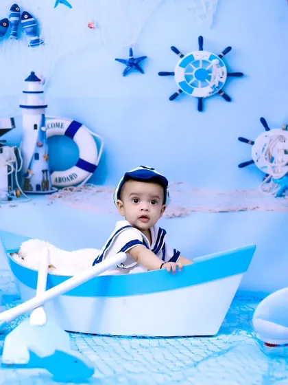 A full view of the sailor-themed setup, with the baby boy looking curiously at his surroundings.