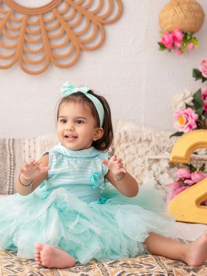 A sweet second birthday portrait. The number '2' prop and the joyful expression mark this special milestone perfectly.