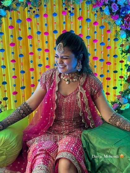 A candid shot of a laughing bride at her colorful mehndi ceremony.