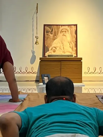 Participants in a Surya Kriya session, practicing with devotion in front of Sadhguru's image. The focus is on precision and inner experience.