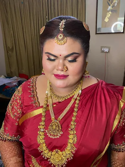 A close-up of a bride's Muhurtham look. Her hair is styled in a classic updo, adorned with temple jewellery, ready for the main wedding ceremony.