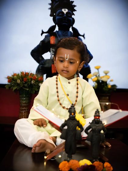 In this shot from the Varkari series, the little boy is posed with a book and prayer beads, adding a storytelling element to the festive baby photoshoot.