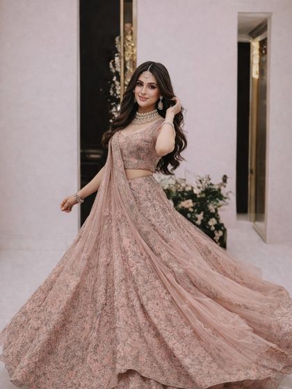A happy and radiant shot in the dusty pink lehenga. This outfit is perfect for a bride's engagement or for a bridesmaid who wants an elegant and sophisticated look.