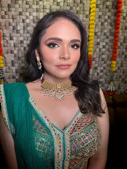 A stunning bride ready for her sangeet or mehendi. Her multi-colored lehenga is paired with a classic gold-tone choker, showing how simple jewellery can perfectly complement a vibrant outfit.