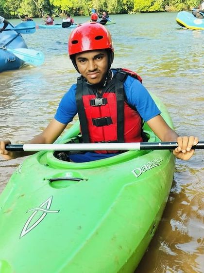A participant gets ready to launch his kayak into the river at the Dandeli summer camp.