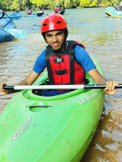 A close-up of a student in his kayak, fully equipped with a helmet and life jacket, ready to learn.