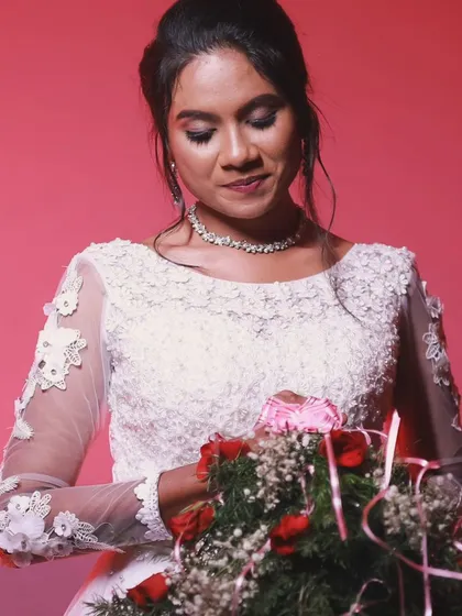 Another shot of the bride holding her bouquet. The soft makeup and elegant hairstyle are perfect for a Christian wedding.