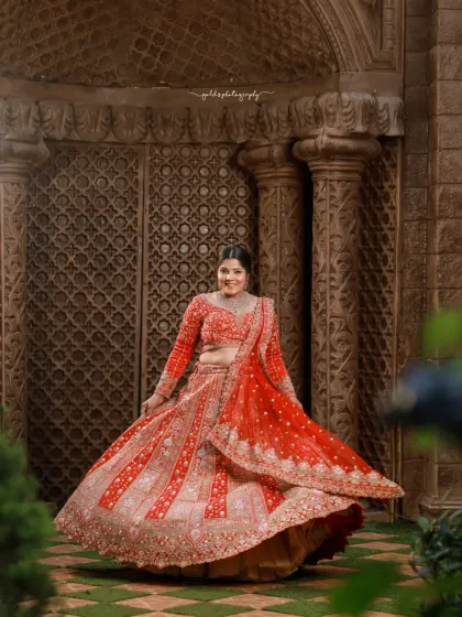 The twirl of a lehenga is a classic bridal shot. This image captures that joyful movement against a grand, palace-like backdrop, creating a fairytale moment.