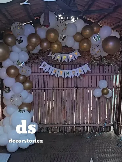 A wider view of the birthday decoration in the rustic hut. The balloon arch and banner effectively transform the space into a festive party zone.