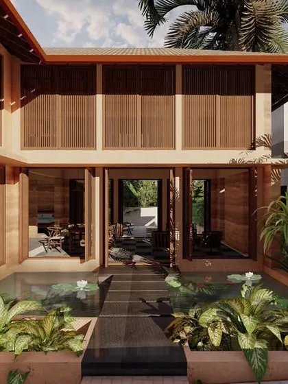 A render of the Morjim Villas in Goa, showcasing the entry to a rammed earth villa through a tranquil lotus pond. This biophilic design element creates a serene arrival experience.