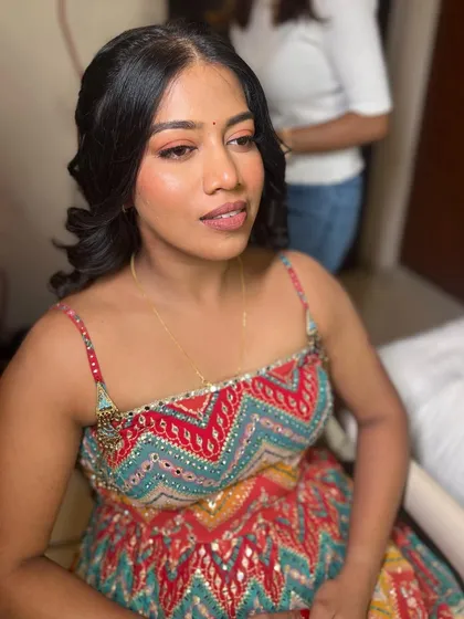 A vibrant Mehendi look. The makeup is colorful and fun, with a focus on the eyes to match the festive outfit.