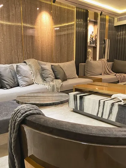 Our design formula is about balancing heavy and light elements. In this living room, a dramatic Panda White marble coffee table anchors the space, while textured wall panels and soft, neutral furnishings create a harmonious and sophisticated atmosphere.