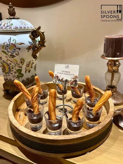 Indulge your guests with decadent desserts like my signature churros served with rich, hot chocolate. This classic treat is always a crowd-pleaser, presented beautifully on a rustic wooden platter for a touch of elegance.