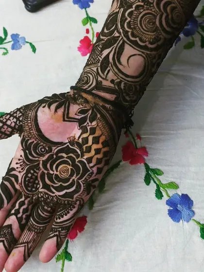 For a more modern feel, I mix different elements like this design. It combines a central floral motif with geometric patterns and leaves negative space on the palm for a contemporary yet intricate style.