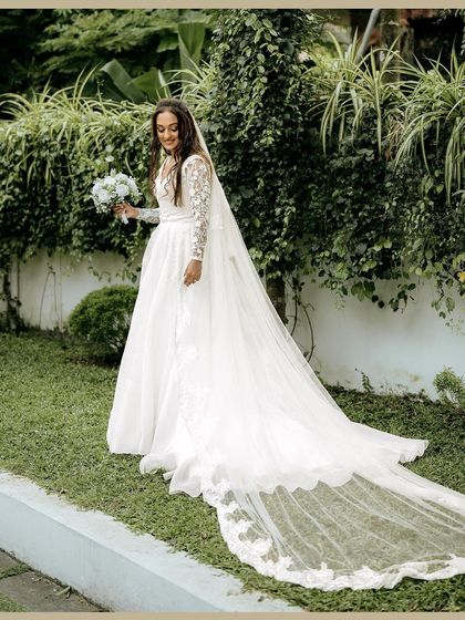A stunning full-length portrait of Elizabeth in her beautiful wedding gown, with a long, elegant veil. This shot highlights the grandeur of a Christian wedding.