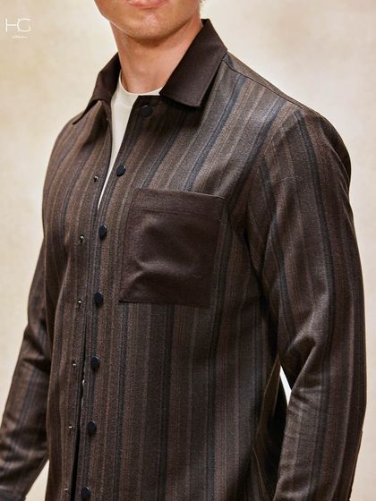 Break the monotony with effortless vintage colors. This striped shacket in earthy brown tones is a perfect example of modern heritage style, ideal for a smart-casual setting.