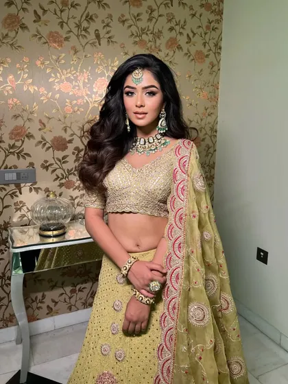 A glamorous look in a lime green lehenga by Faabiiana, perfect for a Sangeet or Mehendi. The styling is chic and modern, with soft waves and sparkling jewellery.
