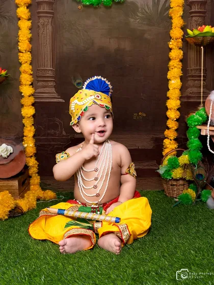 An adorable 'Little Krishna' themed portrait, perfect for celebrating Janmashtami or creating a culturally significant memory. I provide the complete costume, including the turban, jewelry, and flute, against a festive backdrop.
