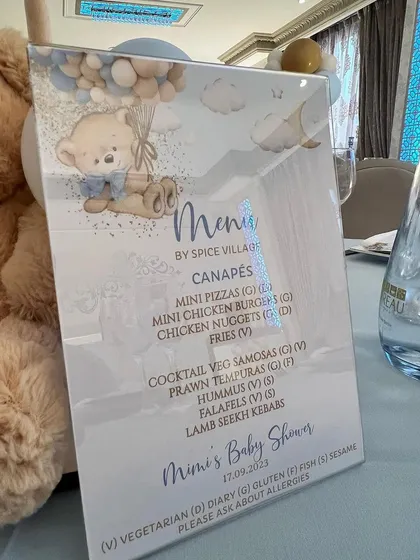 A personalized menu for the baby shower, designed with the same cute teddy bear and balloon graphics to match the overall party decor.
