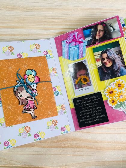 A beautifully arranged scrapbook page with space for multiple photos and a handwritten message, decorated with floral patterns and cute character stickers.