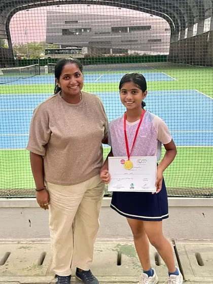A young medalist with her mother, showcasing the strong family support that fuels our players. We view parents as partners in our athletes' development.