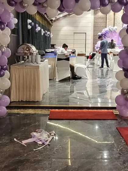 The entrance to the party hall, decorated with a matching purple and silver balloon arch to welcome guests into the celebration.