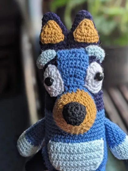 A close-up of the Bluey doll's face.