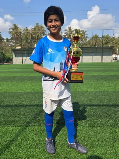 A happy U12 player showing off his hard-earned trophy.