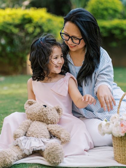 A mother and daughter sharing a sweet moment on a picnic blanket. The connection between them is beautiful.