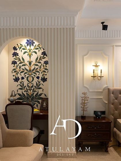 A view showing the arched study nook with its floral stone inlay, set beside a cozy armchair and the main sleeping area.