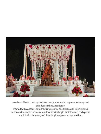 This mandap, draped with cascading mogra strings, suspended bells, and fresh roses, is a sacred space where love stories begin their forever. The design captures an ethereal blend of ivory and maroon, creating a feeling of serenity and grandeur.
