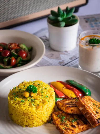 A plated version of my Shish Tawook meal, showing the chickpea pilaf, grilled paneer, and fresh vegetables.