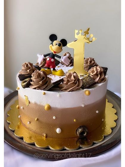 A sophisticated Mickey Mouse cake with a brown and gold ombre design. This is a great option for a first birthday with a classic theme.