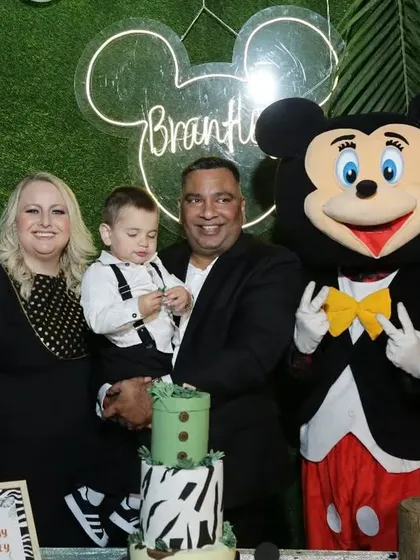 A happy family posing with Mickey Mouse at their son's jungle safari birthday. I can arrange for live characters and mascots to interact with guests and make the party even more special.