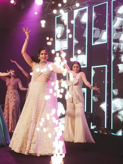 The bride's grand entry to the stage with her bridesmaids, complete with cold pyro for a touch of sparkle.