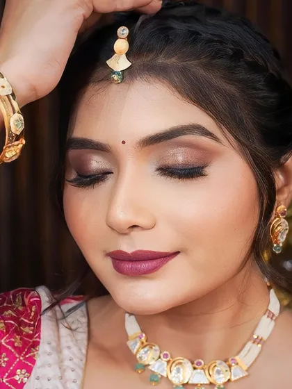 A close-up of the smoky, shimmery eye makeup and bold berry lip. This look is perfect for a sangeet or reception, offering a touch of drama and sophistication.