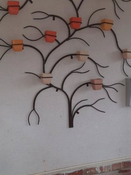 Another version of the tree-shaped wall planter, this time in a dark finish with terracotta-coloured pots. This shows how the same design can be customized to create a different look.