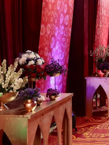 The walkway decor, showing how we use lighting to highlight the rich red drapes and floral arrangements, creating a warm and inviting path.