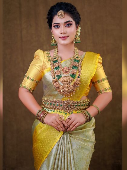 This silver and yellow silk saree creates a unique and elegant look. The draping is done to show off the beautiful contrast border and the richness of the silk.