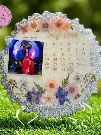 This sparkling silver resin frame was created to celebrate a long and happy marriage. It includes a photo from the special day and a calendar marking the month it all began.