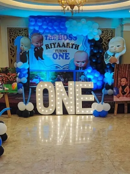The main stage for a Boss Baby first birthday, featuring a large 'ONE' marquee sign and character cutouts.