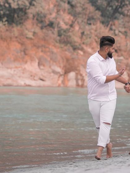 A candid and playful interaction between the couple during their riverside pre-wedding walk.