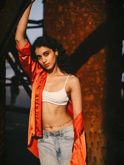 This pose is strong and empowered, using the solid structure of the pier as a prop. The lighting highlights the model's form beautifully.